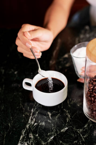 istock Woman putting sugar in coffee 1211504268