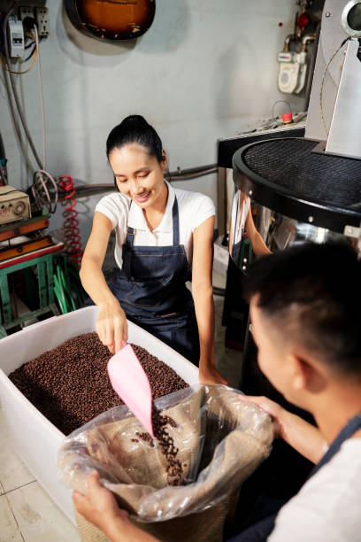 istock Young people packing roasted coffee 1211504269