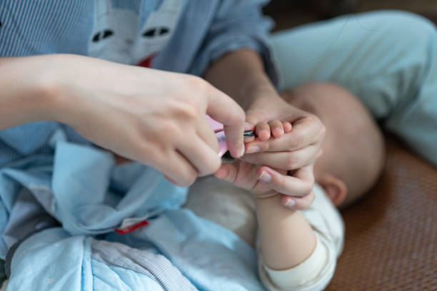 istock A mother cuts her nails for a sleeping child 1211505857