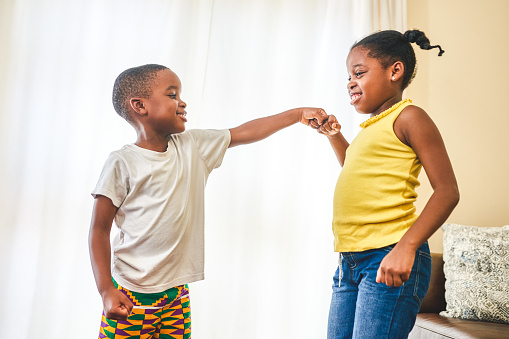 Shot of two young siblings giving each other a fist bump