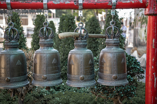 A row of small bronze bells in the garden of a Buddhist temple in Central Bangkok