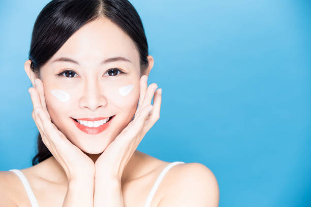istock woman apply sunscreen on face 1211512946