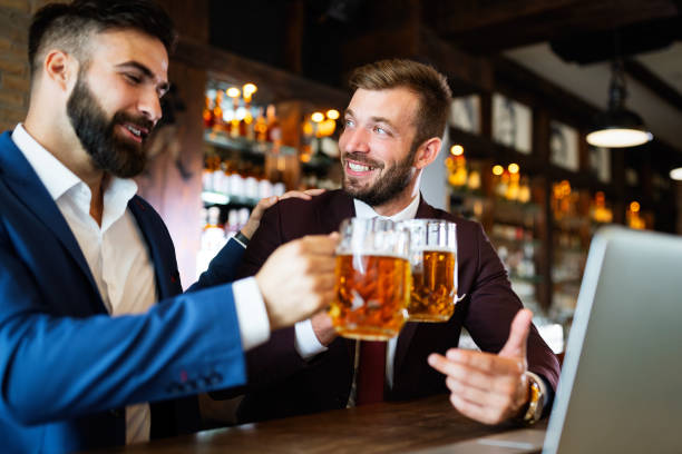 istock Handsome businessmen are drinking beer, talking and smiling while resting at the pub 1211513465