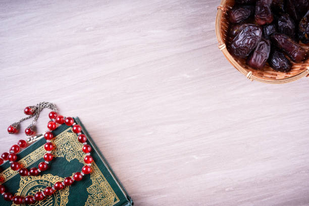 Flat lay composition of Qoran and Tasbih Flat lay composition of Qoran and Tasbih (prayer beads beads). The words on the Qoran is arabic character which means the Holy Qoran kaabah stock pictures, royalty-free photos & images