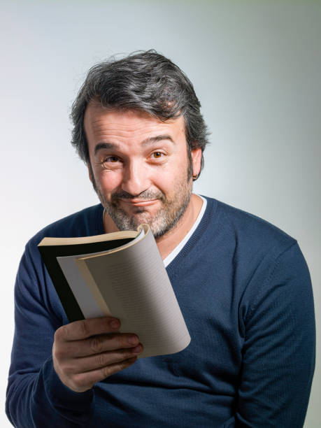 istock Casual man reading a book 1211514216