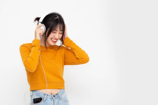 joven mujer de belleza asiática escuchando música con auriculares en la aplicación de la canción de lista de reproducción en el teléfono inteligente aislado en el fondo blanco - samba dancing audio fotografías e imágenes de stock