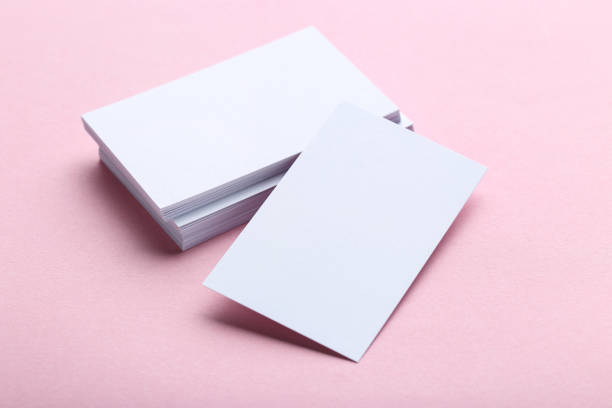 istock Blank business cards on pink background 1211517361