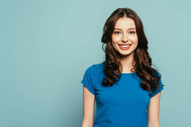 istock attractive, happy girl smiling at camera while standing isolated on blue 1211518115