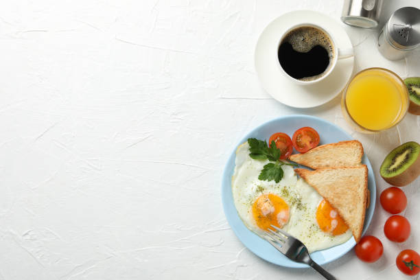 istock Delicious breakfast or lunch with fried eggs on white background, space for text 1211525701