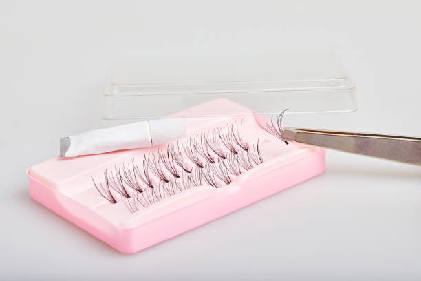 Artificial (false) eyelashes with glue on white Artificial (false) eyelashes with glue on a white background. Accessories for eyelash extensions. clump eyelashes stock pictures, royalty-free photos & images
