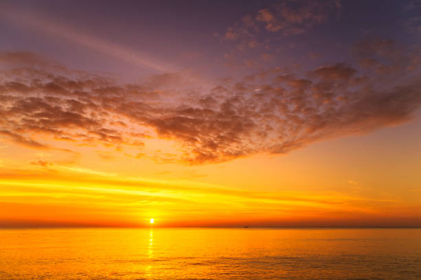 istock sunset with large yellow sun under the sea surface 1211528552