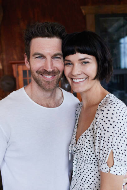 istock Loving young couple smiling while standing together at home 1211531078