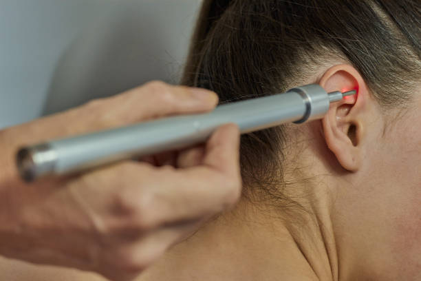 istock Laser therapy. Physical therapist treating patient ear 1211533373