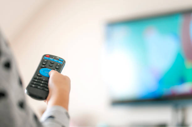 istock Watching animated cartoon on TV remote control in hand 1211534400