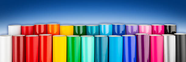 istock Row of various rainbow colored vinyl car wrapping or plotter cutting sticker foil film rolls  blue white wide panorama banner background 1211537583