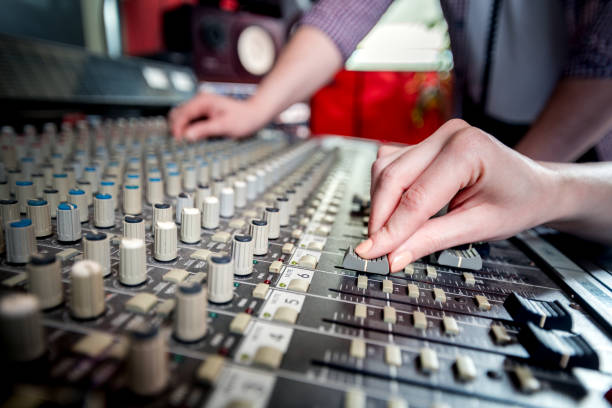 istock Music engineers working together in recording studio using mixing desk 1211539674
