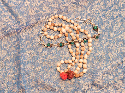 a pebble colored Indian necklace on a indian scarf.