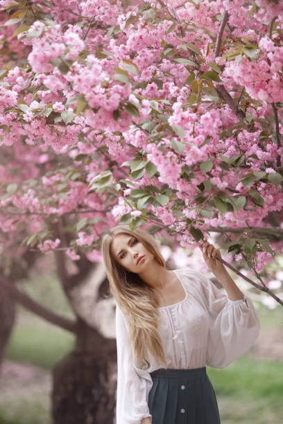 istock Woman at Blossoming Sakura Tree on Nature 1211540156