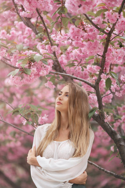 istock Woman at Blossoming Sakura Tree on Nature 1211540259