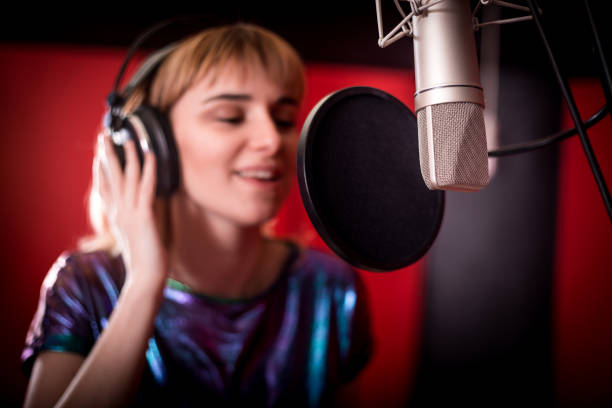 istock Young singer woman during music session at recording studio 1211541386