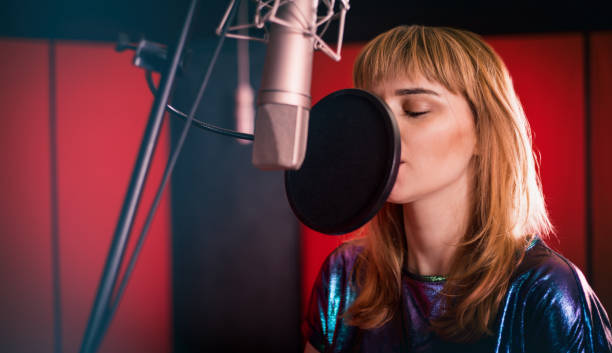 istock Young singer woman during music session at recording studio 1211541567