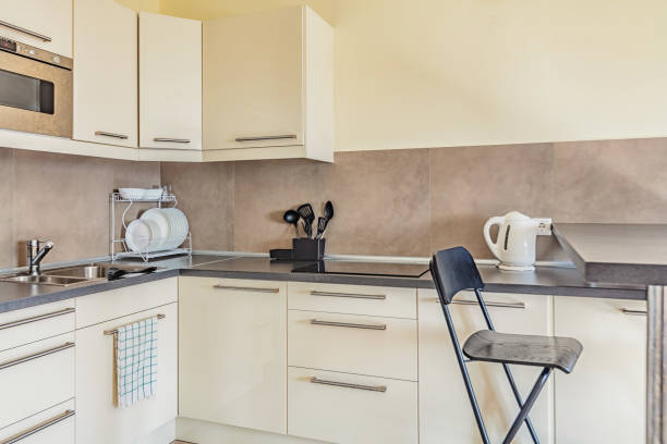 günstige leichte kleine saubere küche in beige farben - small domestic kitchen apartment rental stock-fotos und bilder