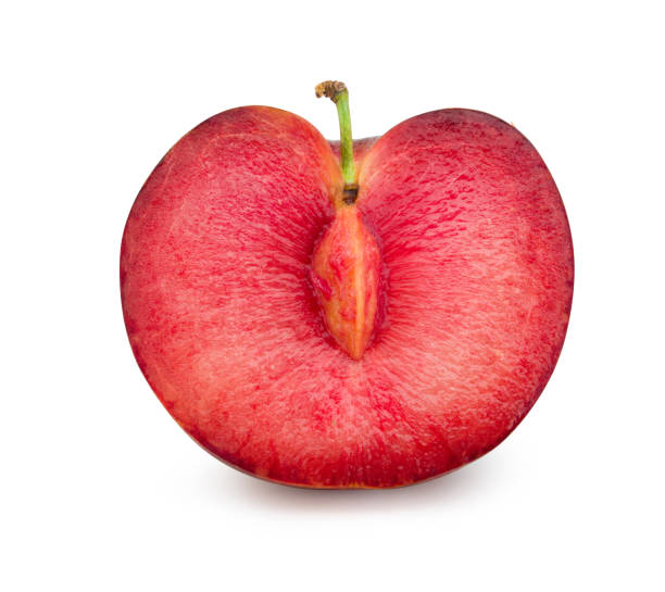 istock Red plum cut in half with seeds isolated on white background. Fresh plum clipping path. 1211543954