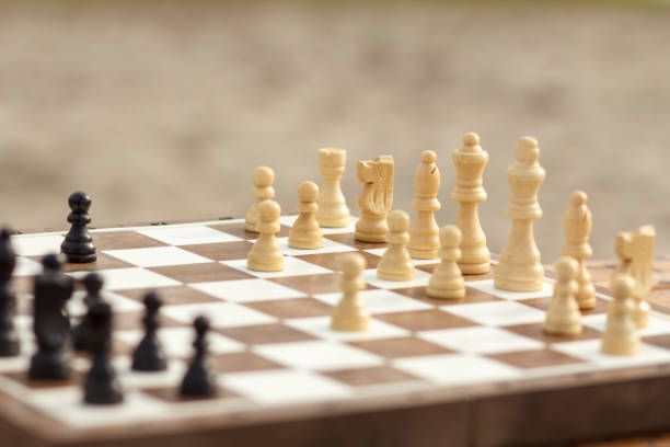 istock Close up wooden chess pieces on board, selective focus on white ones 1211544459