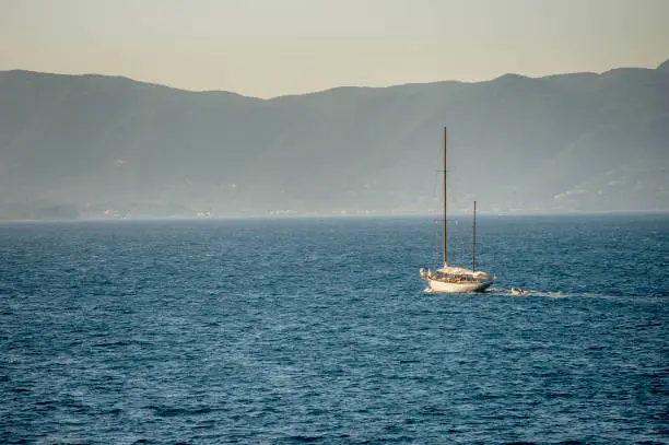 A wooden sailing boat motoring to the harbour in Greece.
