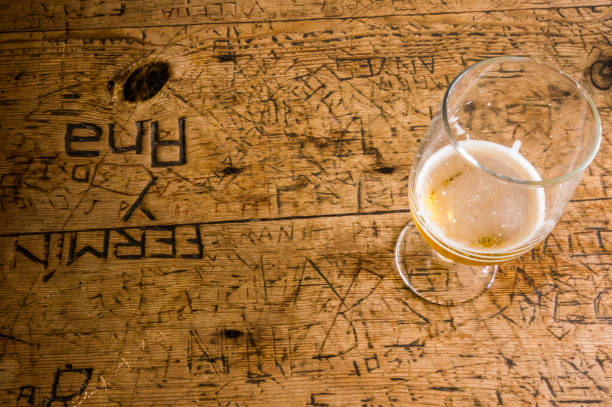 Glass of beer on an old table with graffiti