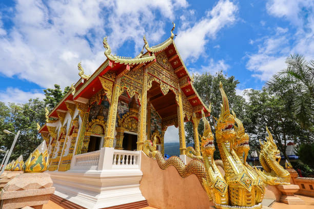 mae hia sub distrito, província de chiang mai, norte da tailândia em septemmber 13,2019:lanna estilo ubosot ou sala de ordenação de wat phra that doi kham é uma estrutura muito ornamentada com um telhado de várias camadas e placas de barcaça naga. - golden temple - fotografias e filmes do acervo