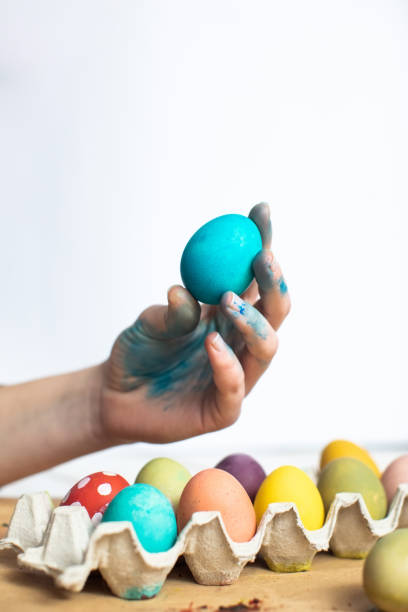 istock Blue Easter egg in woman hand. The process of painting Easter eggs 1211547067
