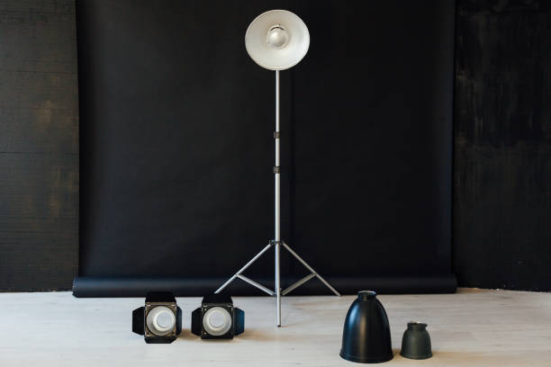 istock Photo studio equipment flash accessories photographer on black background 1211547222