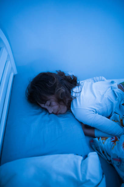 istock Small 11 year old girl sleeping in bed on a stomach. 1211548238