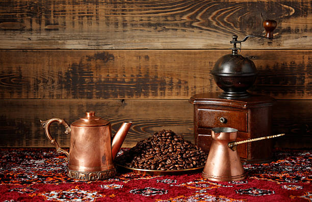 Traditional coffee pot or cezve sits on a gas stove, prepared for brewing, surrounded by a simple kitchen setting. Real photo.