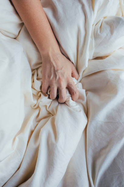 hand grabbing a bed sheet - bedroom authority indoors home interior imagens e fotografias de stock