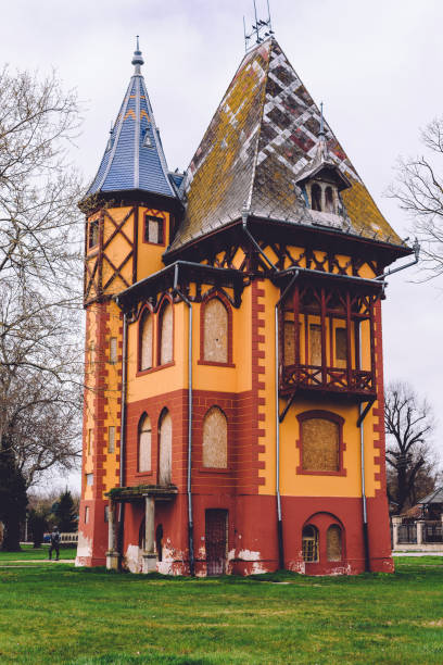 Subotica, Serbia - April 4, 2018. Abandoned Owl tower with tiled rooftop and woodcarving decorative details. Palic castle or Bagolyvar villa on shore of lake is popular landmark and hungarian architectural monument.