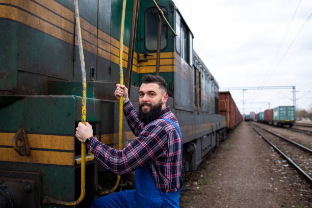 istock Engine driver boarding train to carry loads to destination. Railways transportation service. 1211552952