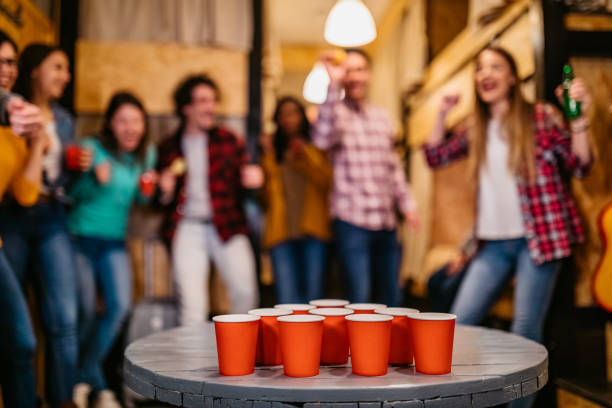 istock Young people playing beer pong in hostel 1211553002