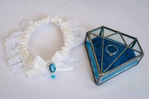 istock Diamond wedding ring on box. Engagement. Woman's garter on a white background. Bride accessories. Stylish blue wedding. 1211554295