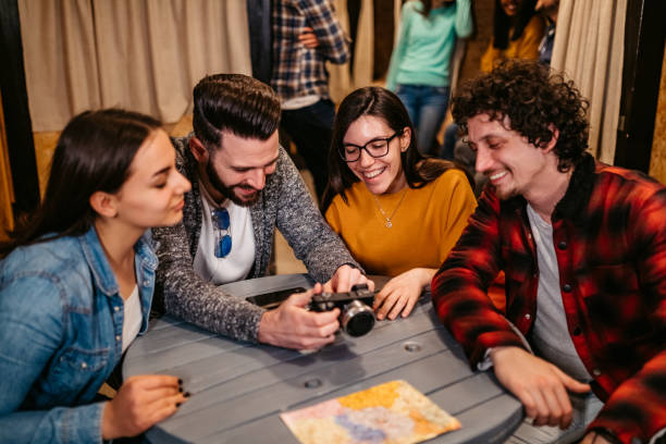 istock Friends watching photos on camera in hostel room 1211554430