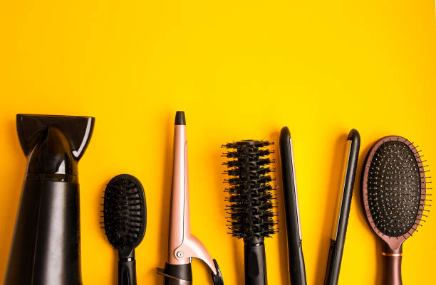 профессиональные инструменты для волос на желтом фоне с копией пространства, вид сверху - hair dryer single object plastic black стоковые фото и изображения