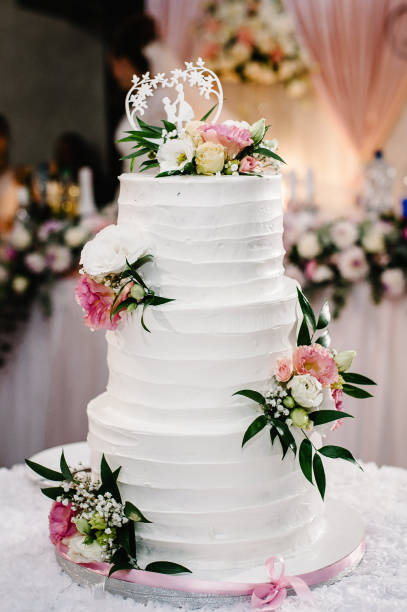 istock White wedding cake with pink flowers for wedding banquet. Delicious reception. Copy space. Celebration party concept. Trendy Cake. 1211555885