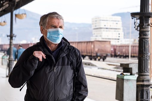 Senior man traveling with Facemask, Slovenia on Italian border.