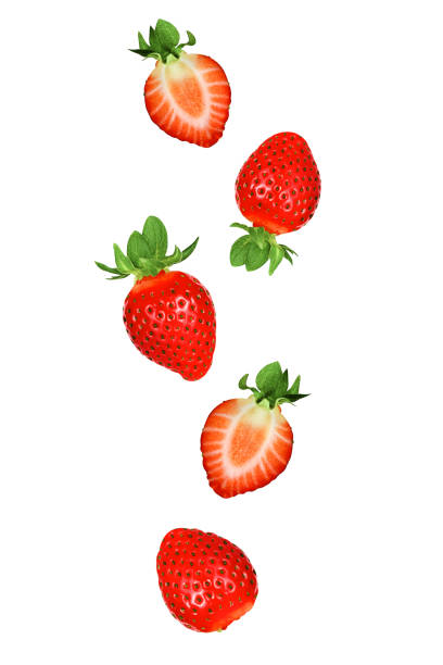 istock Falling strawberries fruits whole and cut in half isolated on white background with clipping path. Flying food 1211556865