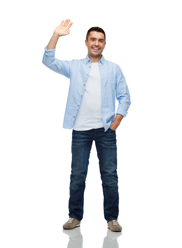 happiness and people concept - smiling man in shirt and jeans waving hand
