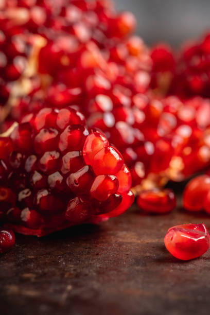 istock Broken red ripe pomegranate fruit on the dark rustic background 1211560302