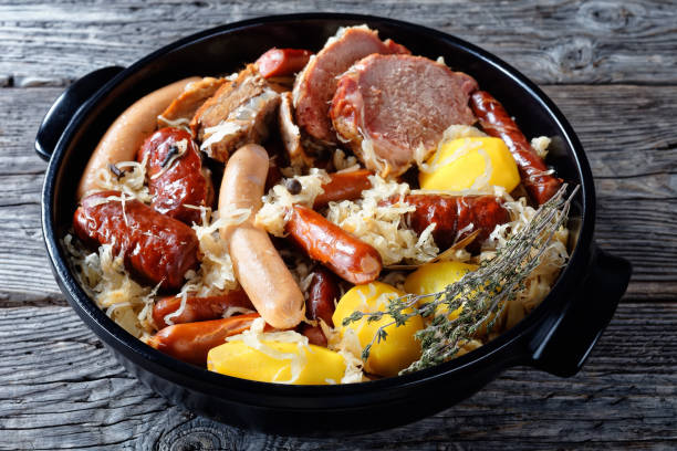 français région alsace plat choucroute garnie de chou fermenté au bacon fumé, longe de porc, saucisses mijotées au vin blanc avec oignon, ail et épices - sauerkraut photos et images de collection