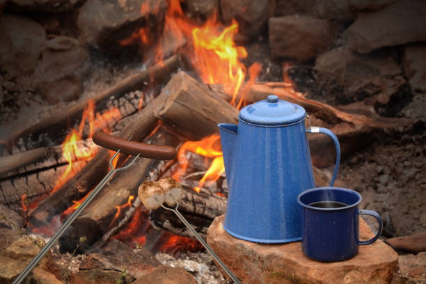 istock Outdoor fire with sausage on a fork with blue jug and mug 121156326