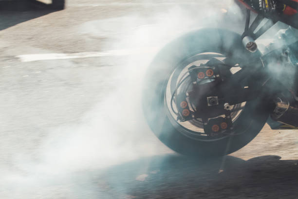 istock motorcycle wheel smokes on asphalt 1211563304